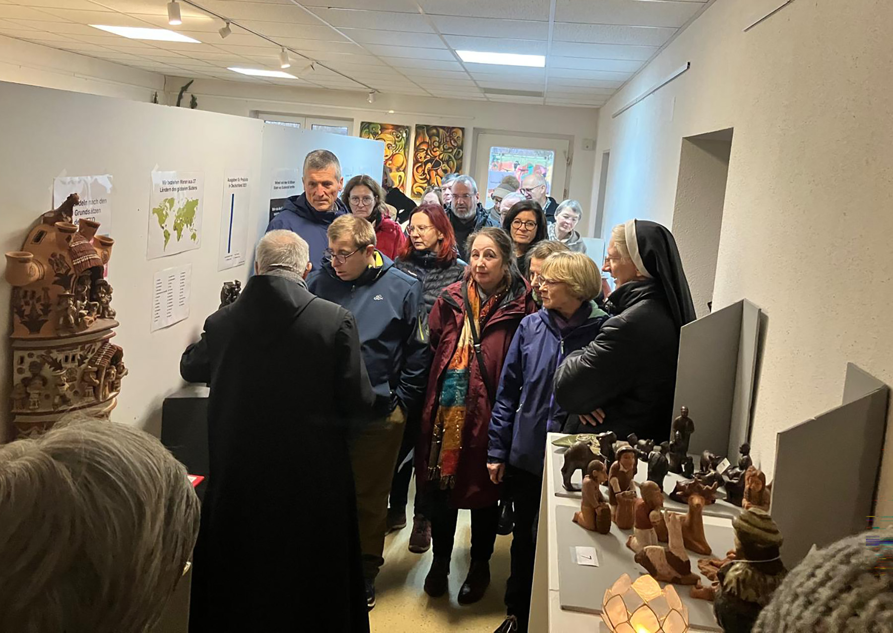 P. Meinrad Duffner führt Menschen durch die Krippenausstellung