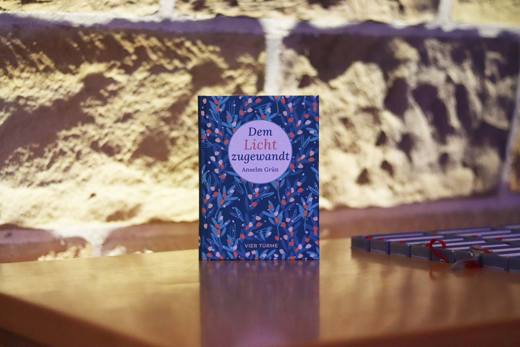 Buch vor beleuchteter Steinwand