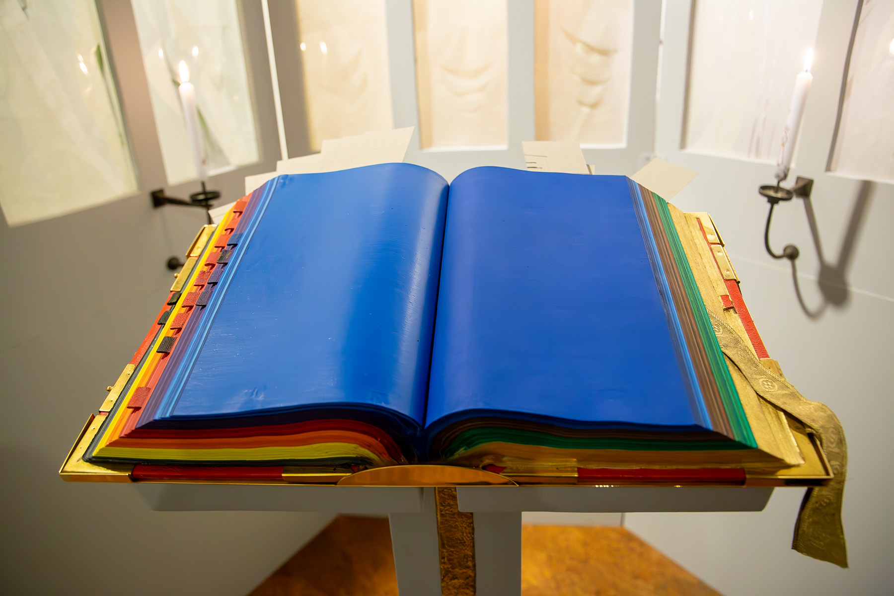 Dickes Buch mit bunt bemalten Seiten auf einen Pult