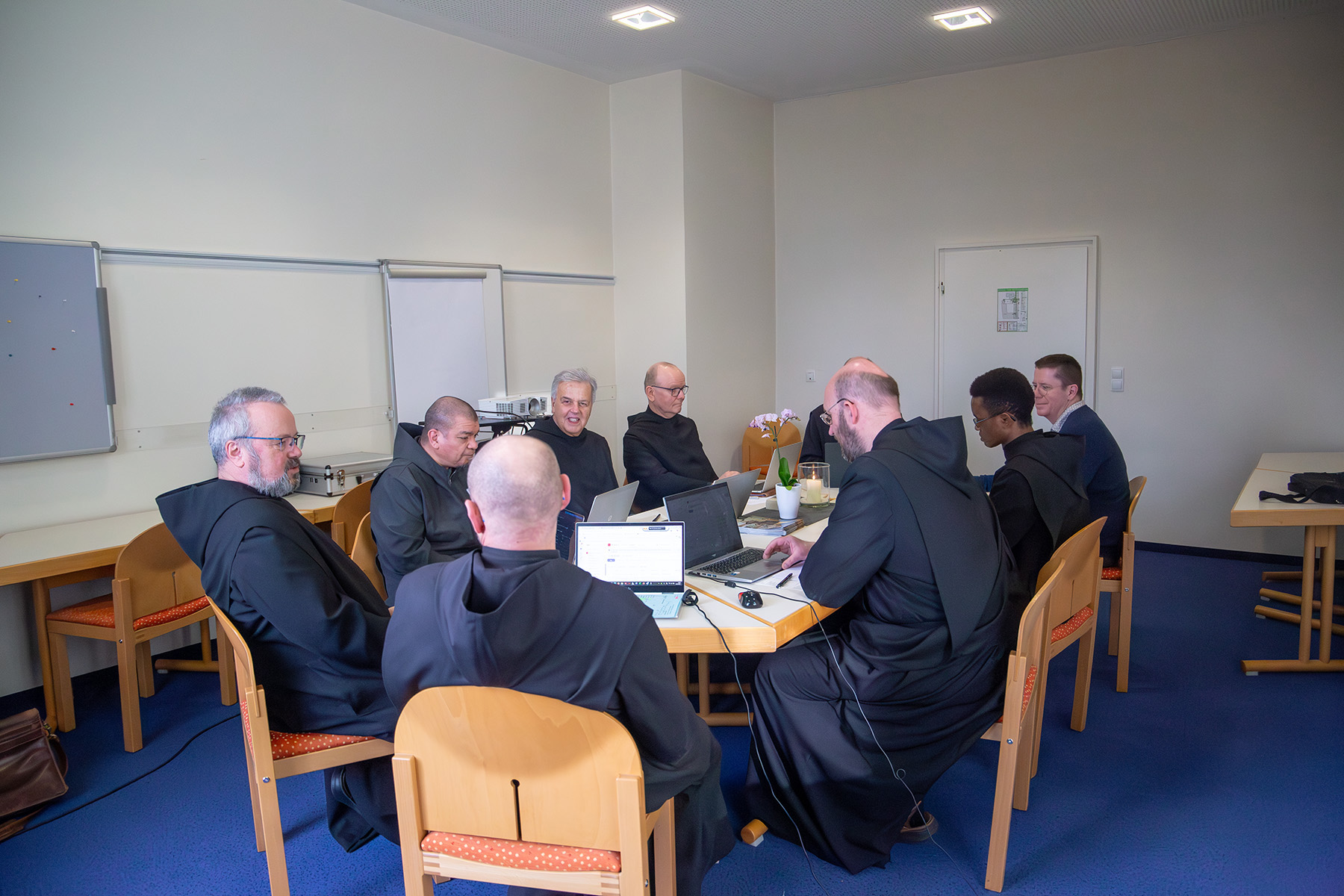 Männer im Habit bei einer Besprechung