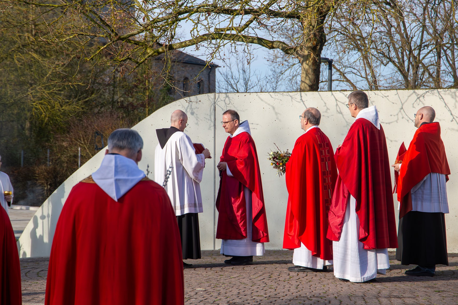 Pater im roten Gewand liest aus der Bibel