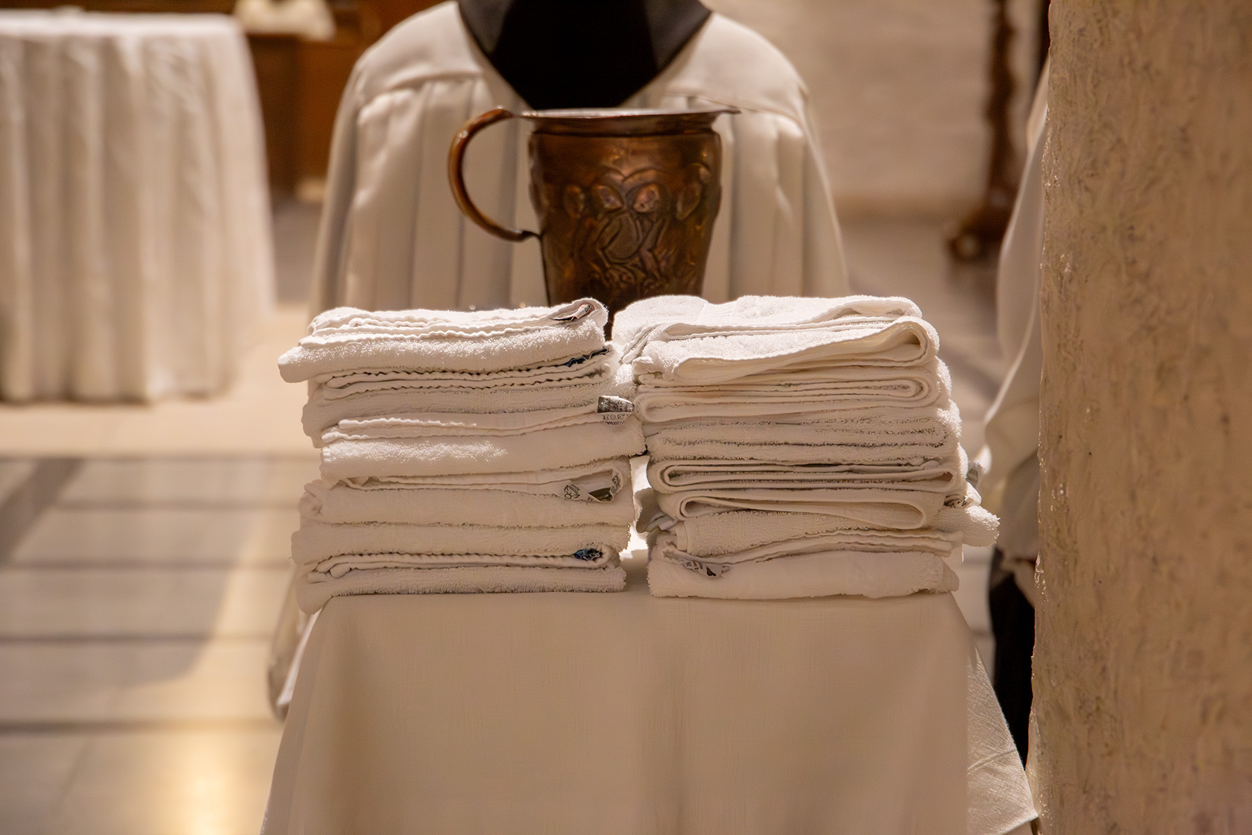 Stapel mit Handtüchern, Wasserkrug im Hintergrund