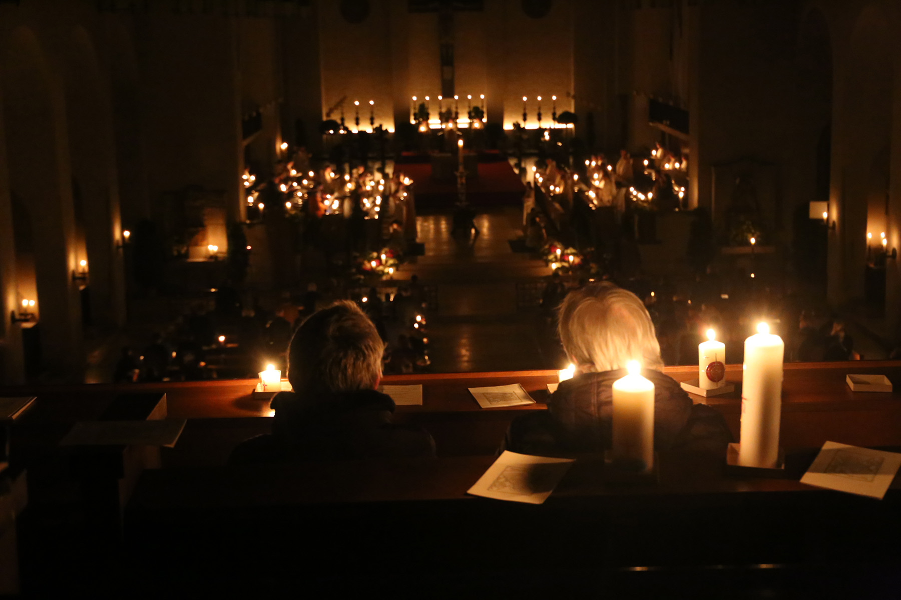 Zwei Frauen von hinten, umgeben von Kerzen