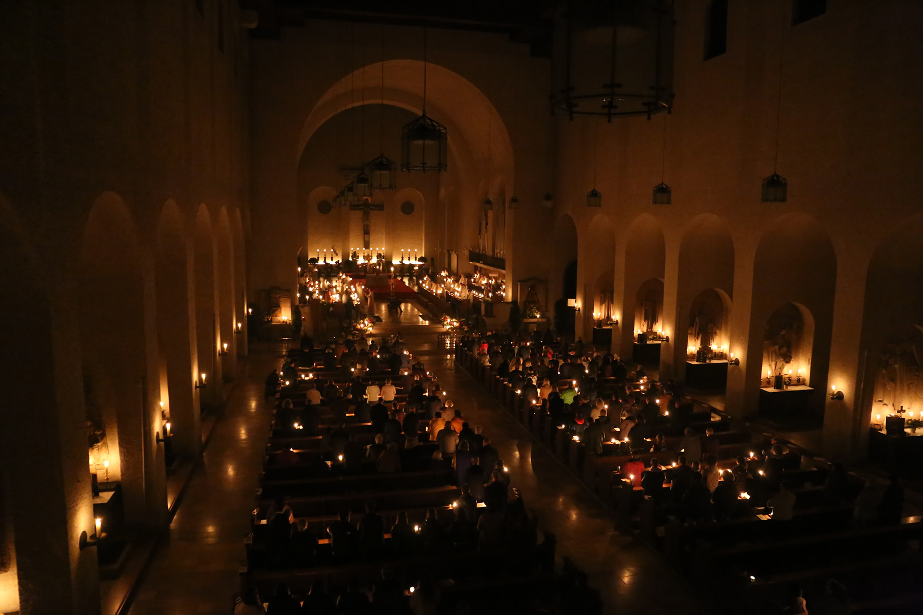 Blick von oben auf mit Kerzen beleuchtete Kirche