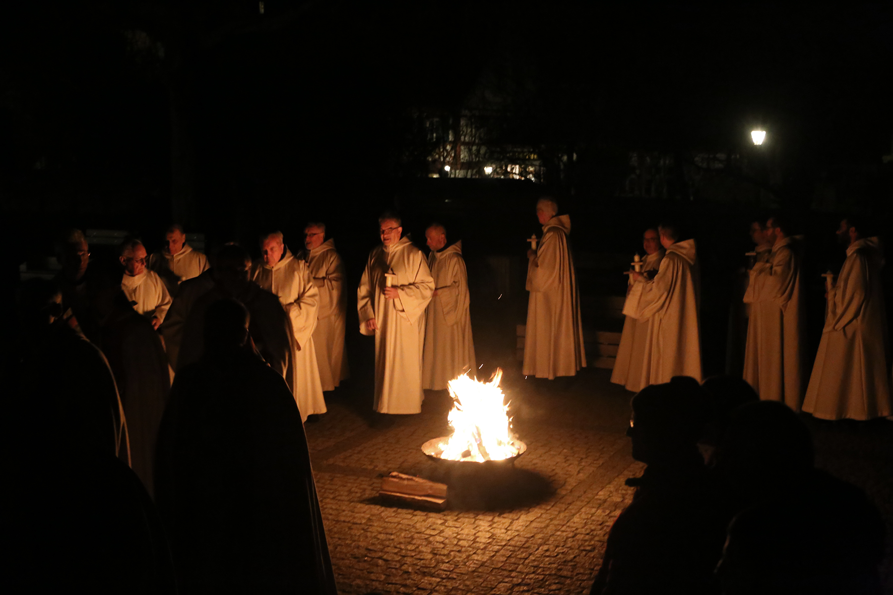 Mönche neben dem Osterfeuer