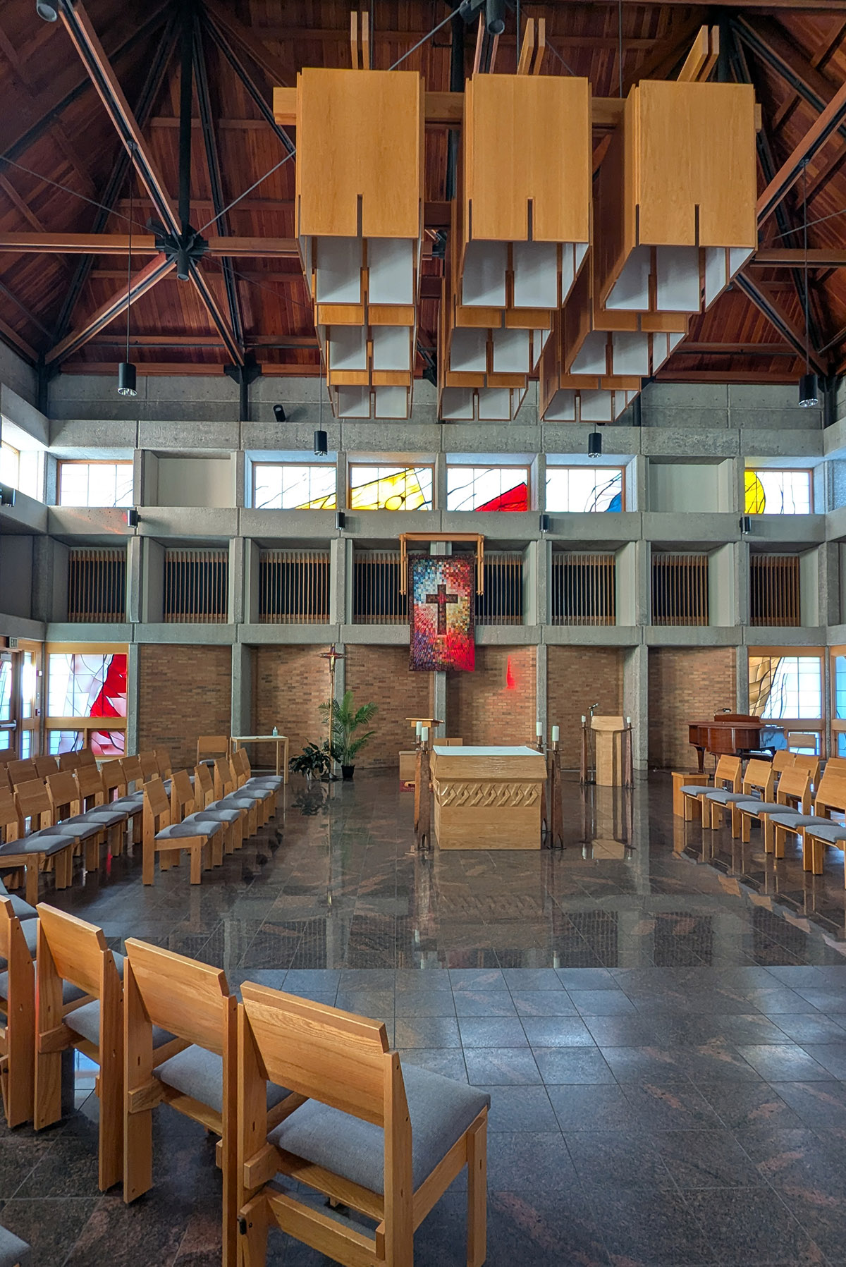 Kapelle mit Stühlen, Tischaltar und großen Holzlampen