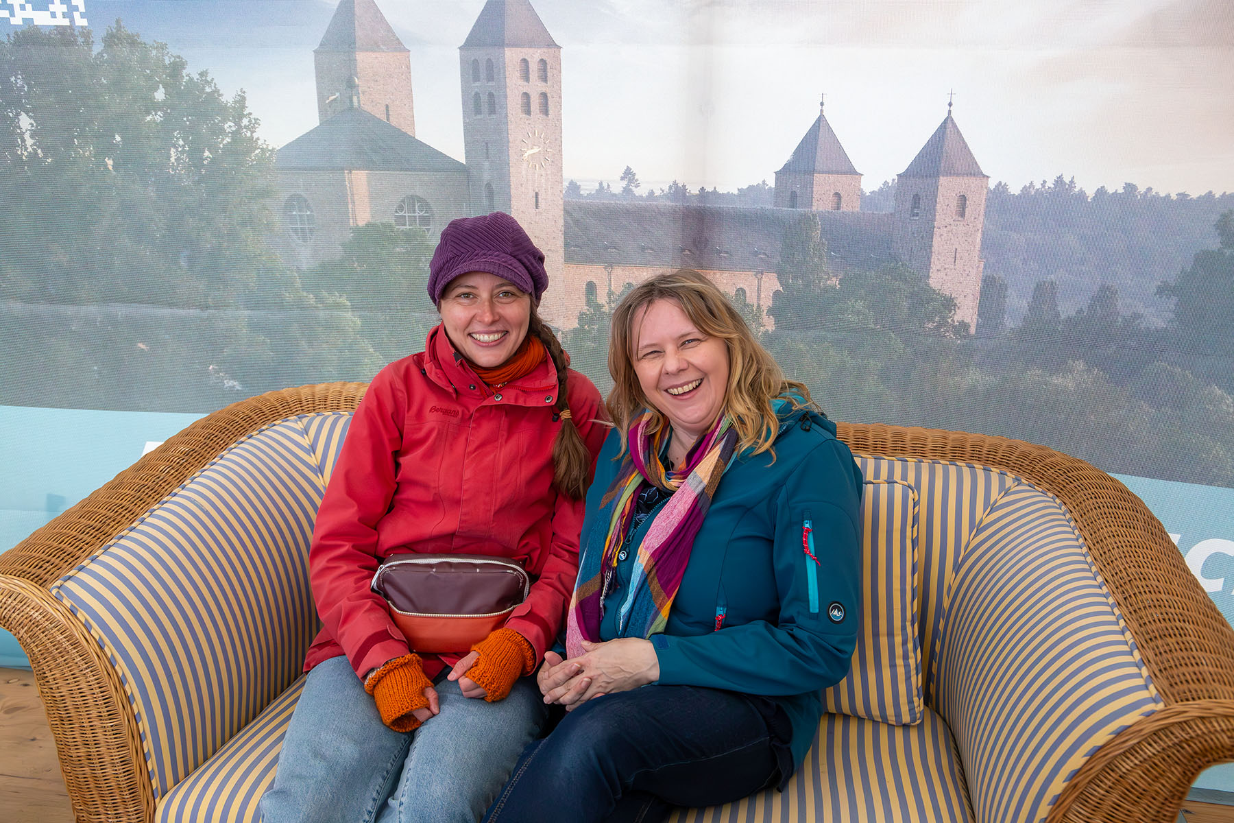 Zwei Frauen auf einem Sofa vor dem Bild der Abteikirche