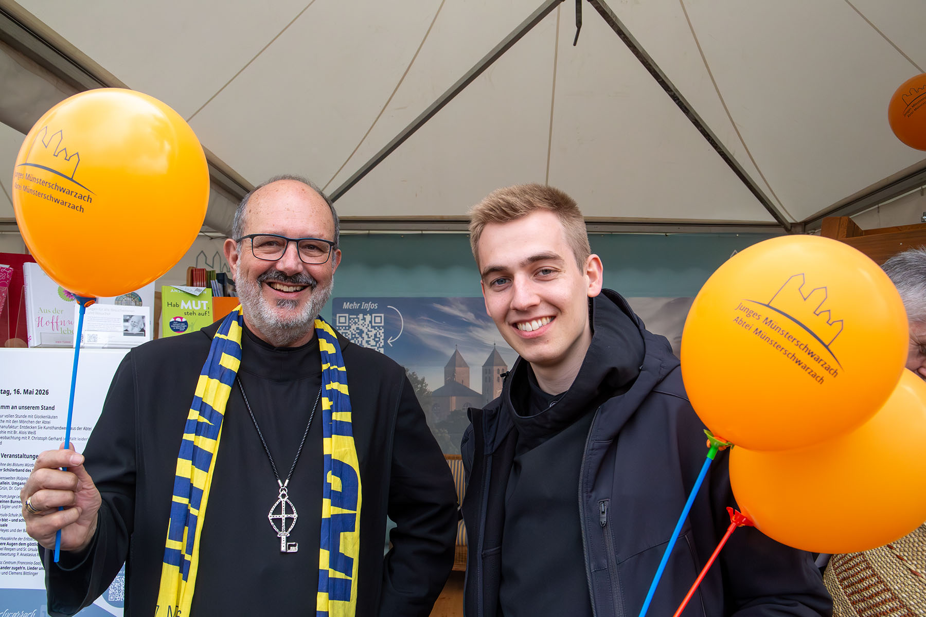 Älterer Mönch und jüngerer Mönch im Habit mit orangen Luftballons