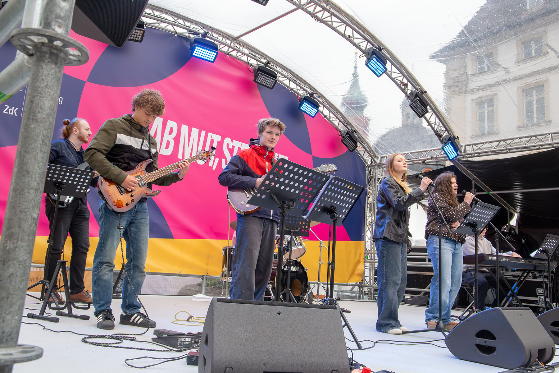 Schüler und Schülerinnen mit Instrumenten auf einer Bühne 