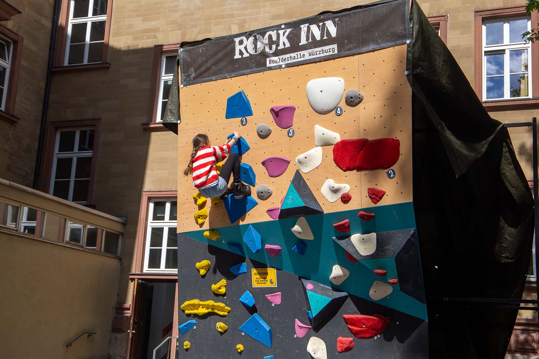 Mädchen an einer bunten Kletterwand