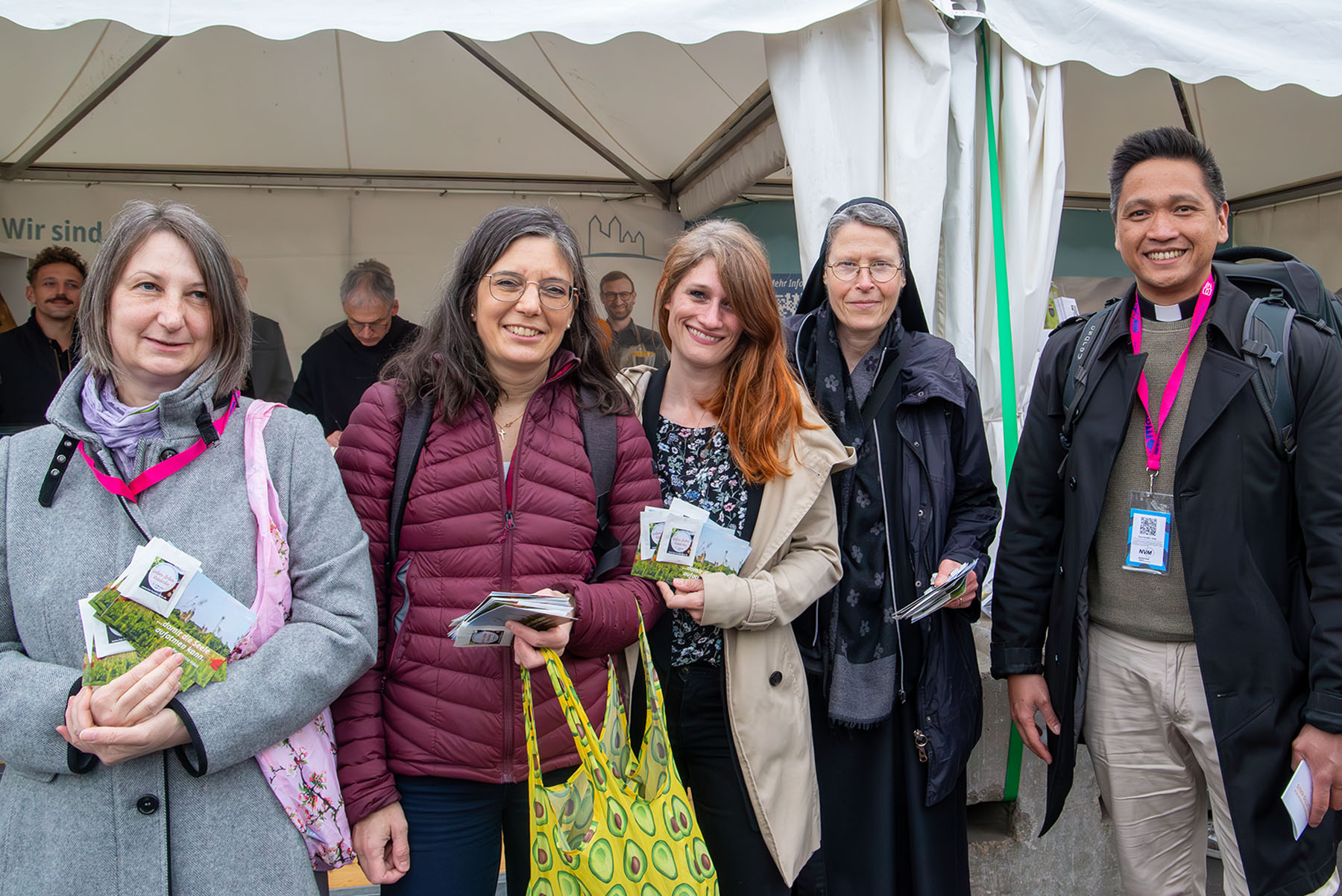 Vier Frauen mit Taschen und Karten sowie ein junger Mann