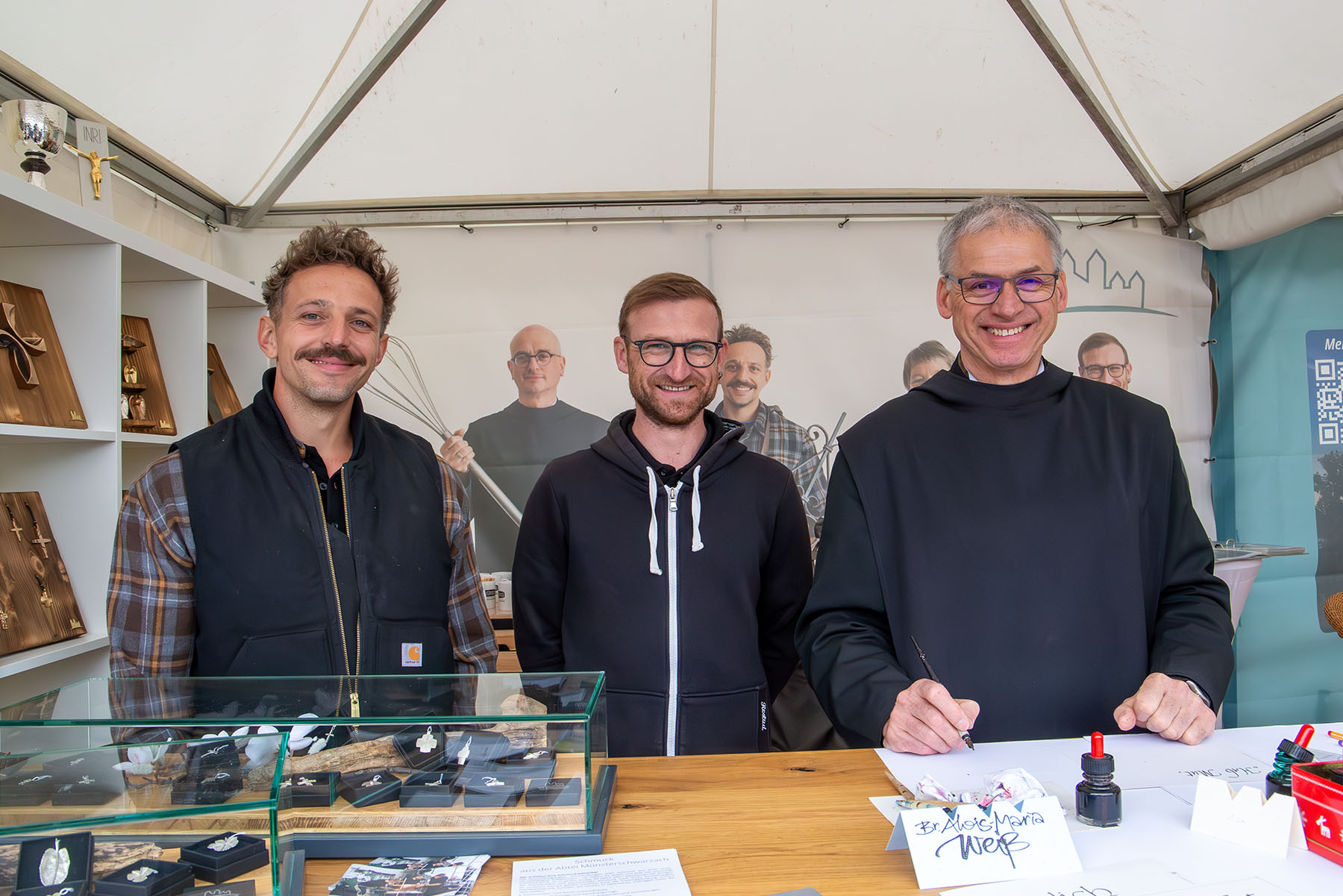 Zwei junge Männer und ein Mönch am Stand