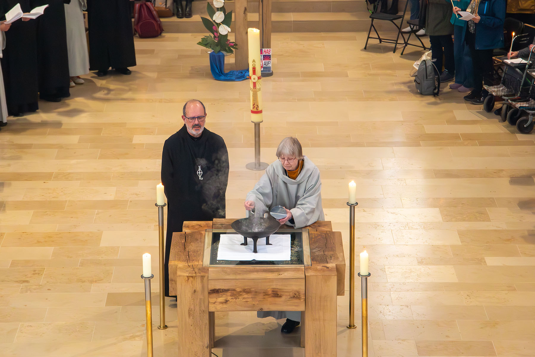 Mönch und Schwester am Altar beim Entzünden von Weihrauch