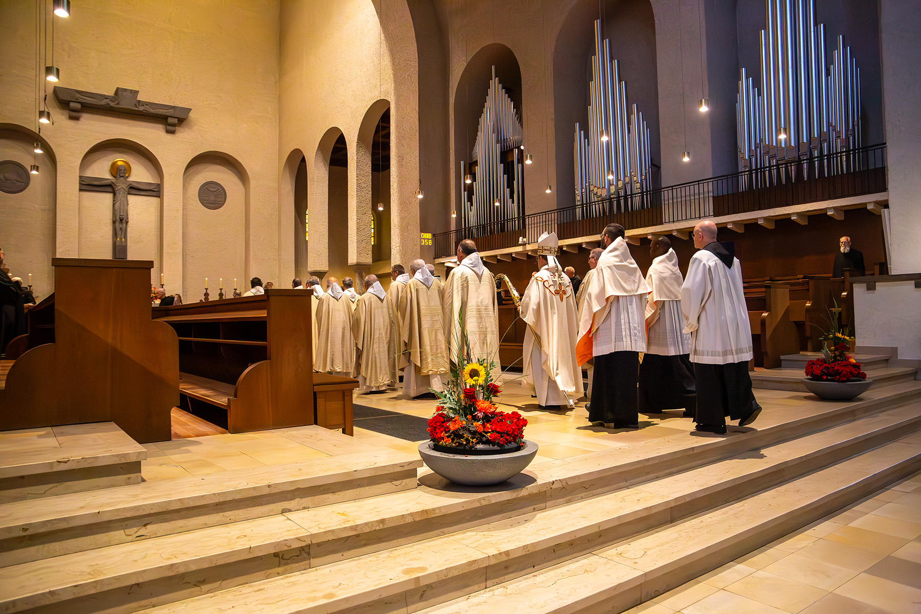 Mönche in weißen Gewändern ziehen in Kirche ein