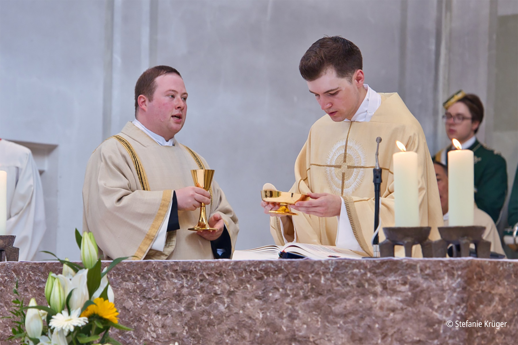 Zwei Priester in weißen Gewändern bereiten Abendmahlsfeier vor