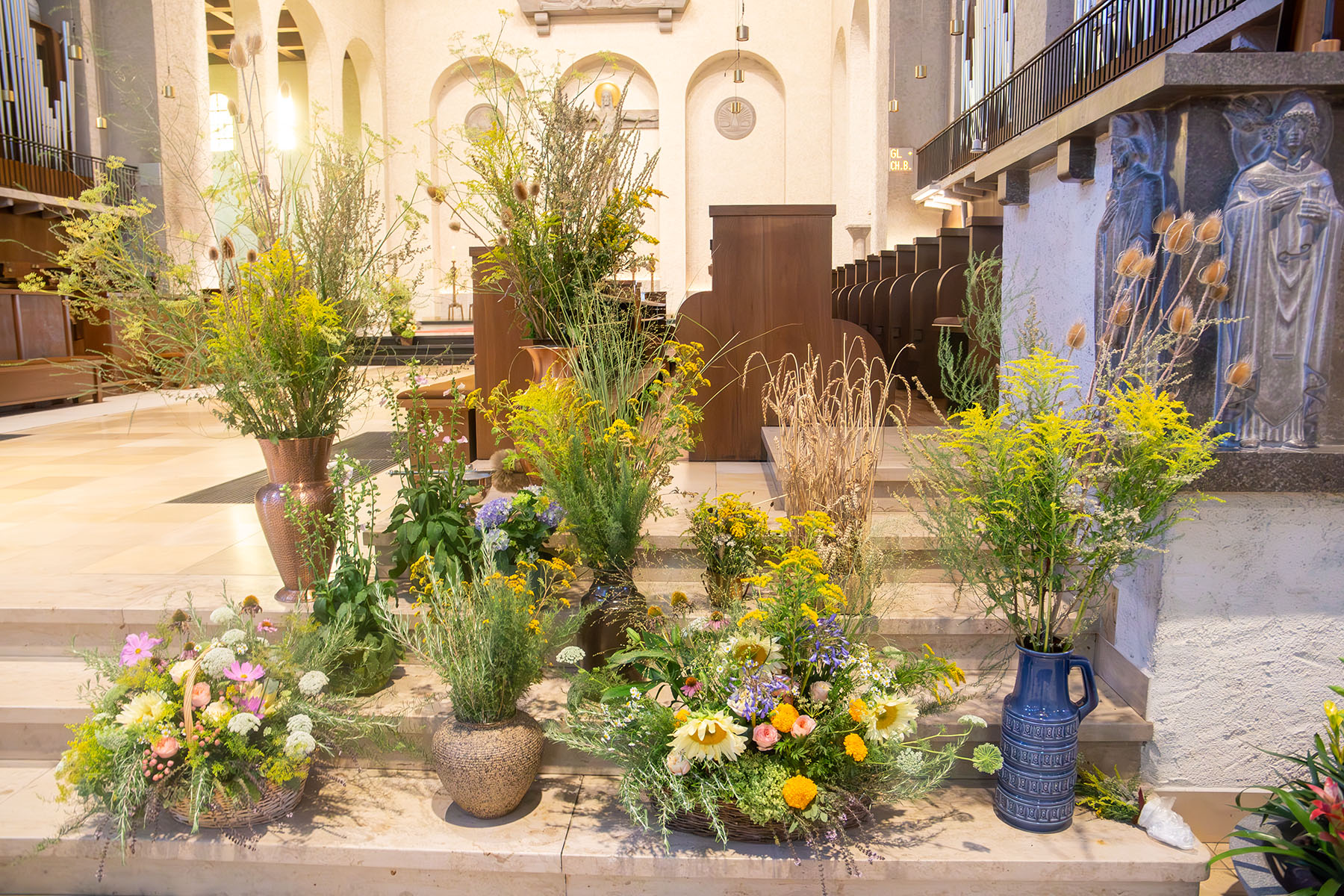 Verschiedene Körbe und Gefäße mit Pflanzen und Blumen