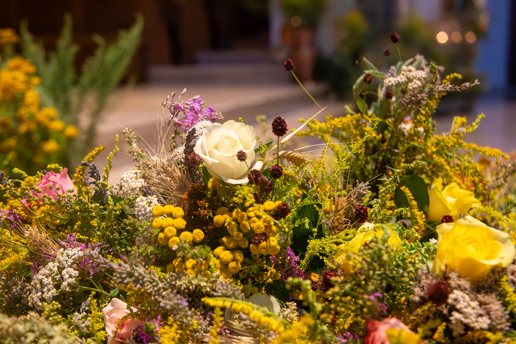 Blick über Blumenschmuck mit einer weißen Rose in die Kirche