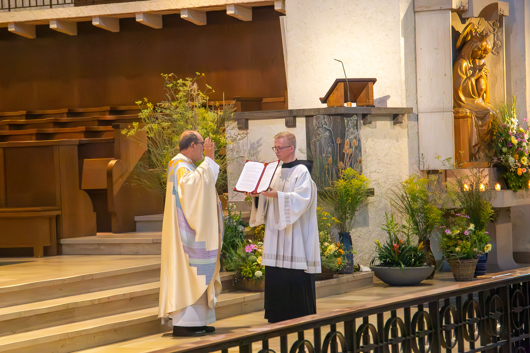 Zwei Mönche in der Kirche, einer hält ein Buch, der andere hebt seine betenden Hände