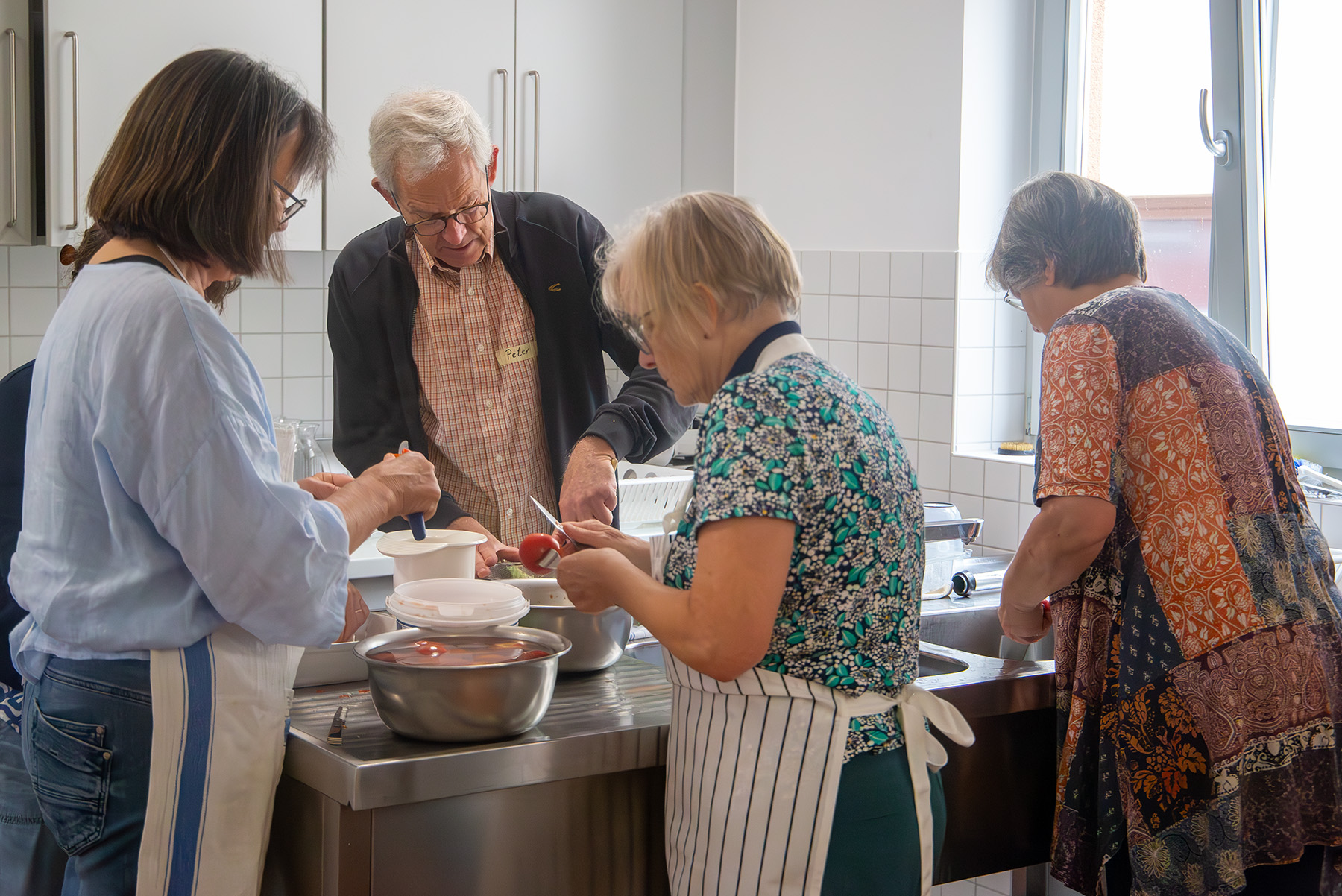 Ein Mann und drei Frauen arbeiten am Küchentisch