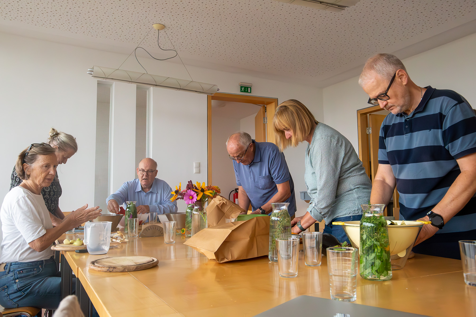 Eine Gruppe von Menschen schneidet Gemüse und Kräuter
