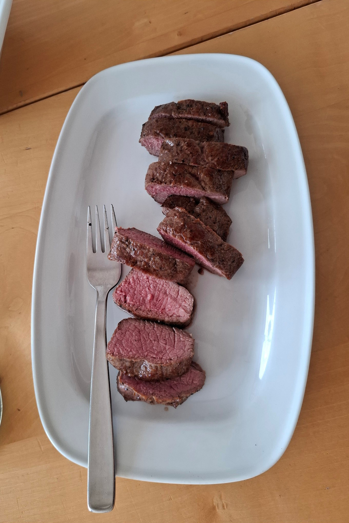 Servierplatte mit Gabel und Fleischstücken