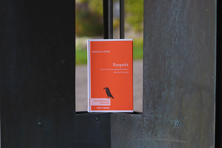 Buch mit rotem Einband steht in einer Metallform