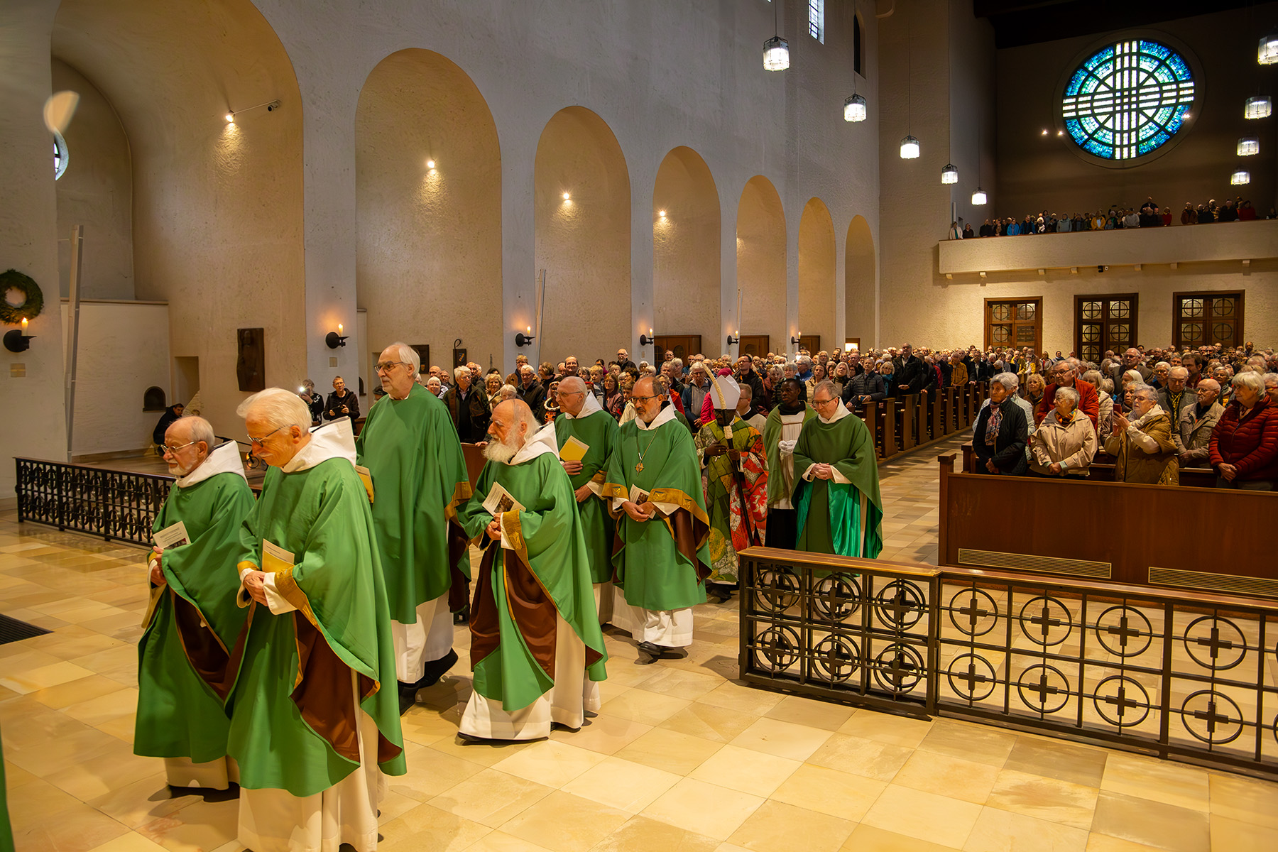 Mönche vor den mit Menschen voll besetzten Kirchenbänken