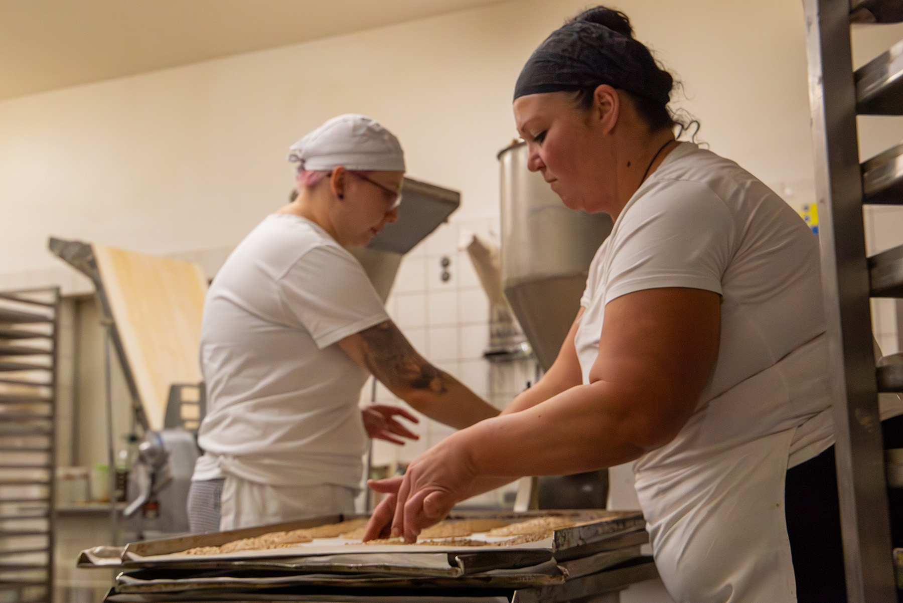 Zwei Frauen arbeiten in weißer Kleidung in der Bäckerei