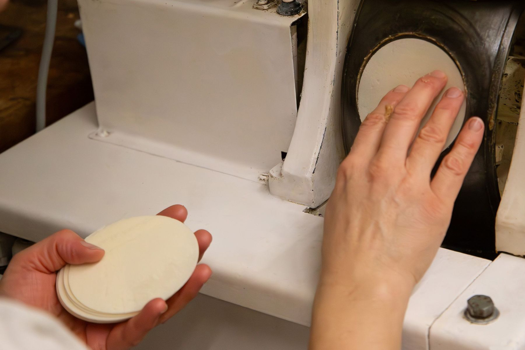 Hand legt Oblate in Maschine ein