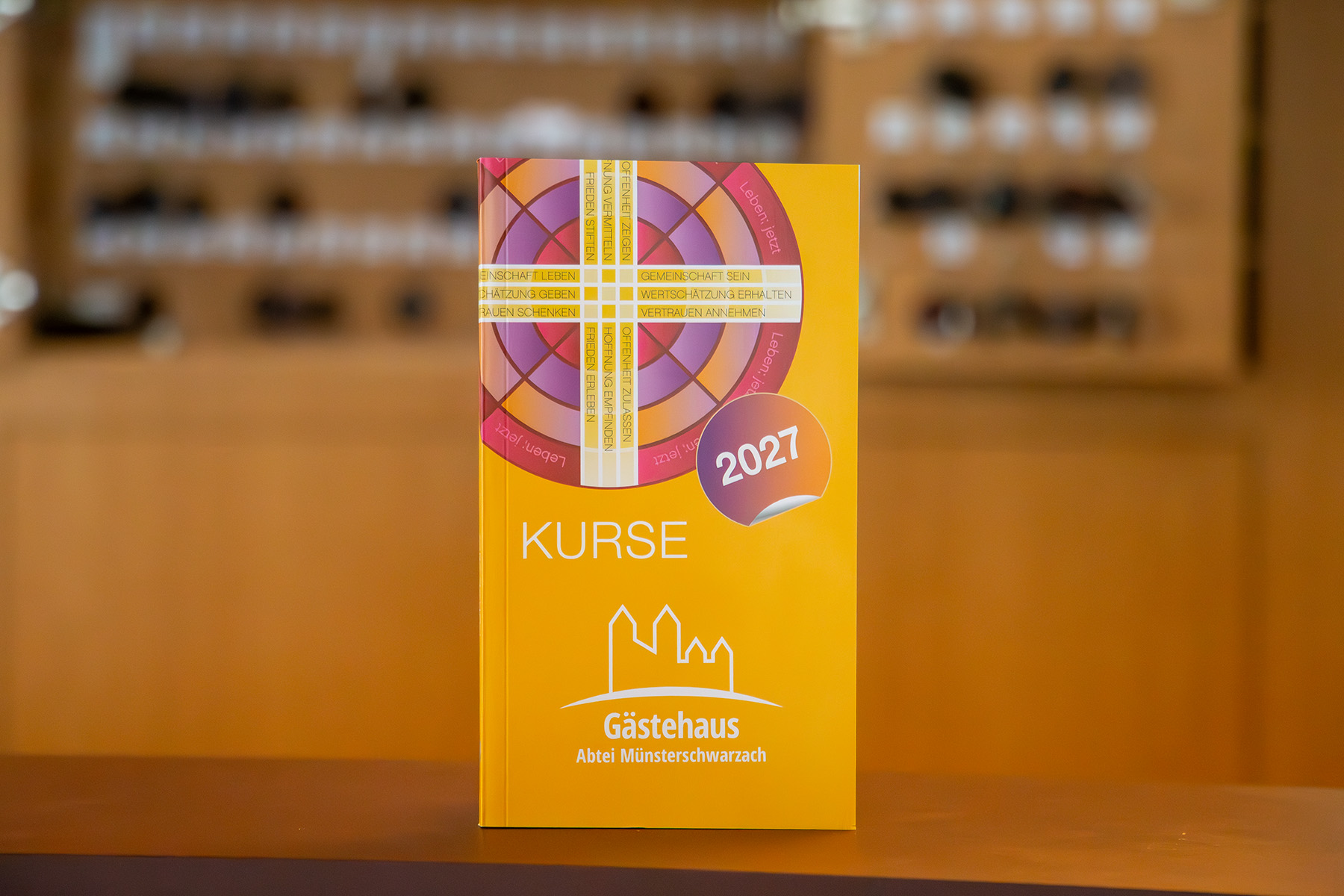 Oranges Buch, im Hintergrund sieht man verschwommen einen Schlüsselkasten