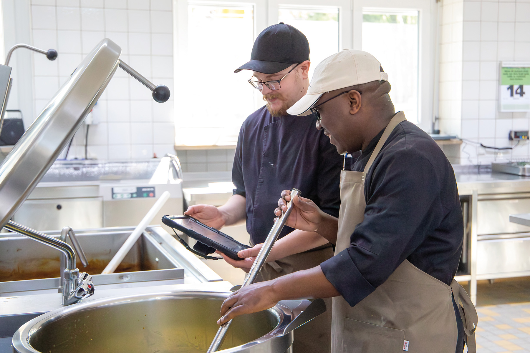 Junge Handwerker arbeiten an einem Kupferkessel