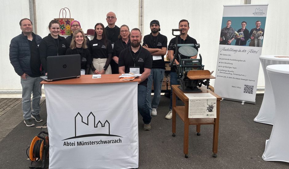 Gruppenfoto mit 5 Frauen und 4 Männern hinter einer Theke mit dem Abtei-Logo