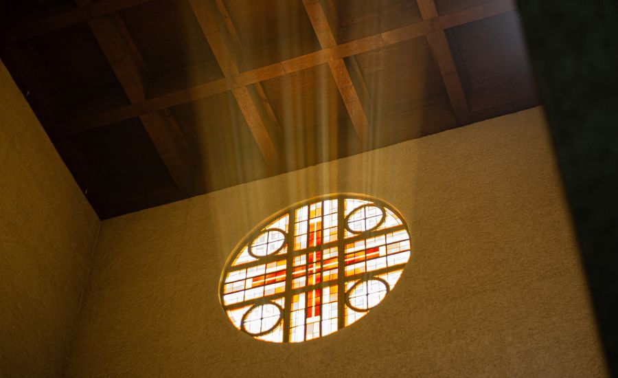 Lichtstrahlen, die durch ein Rundfenster in die Kirche fallen