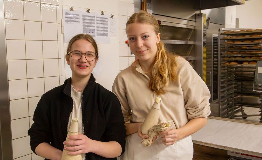 Zwei Mädchen mit Spritztüllen in der Bäckerei