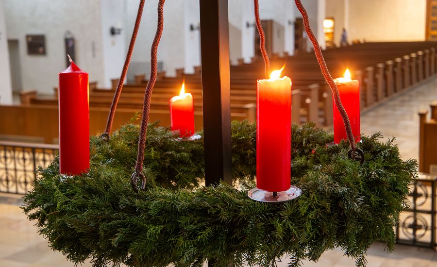 Adventskranz, bei dem drei Kerzen angezündet sind.