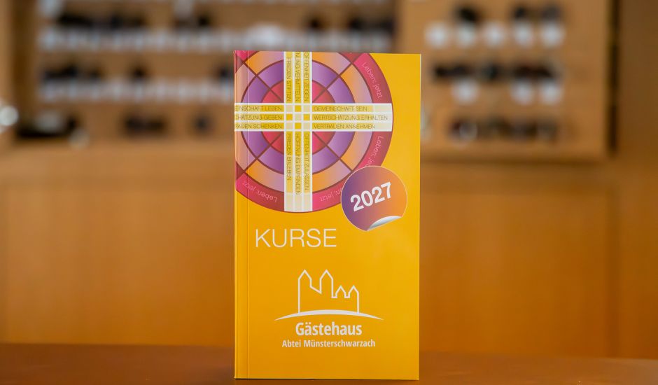 Oranges Buch, im Hintergrund sieht man verschwommen einen Schlüsselkasten