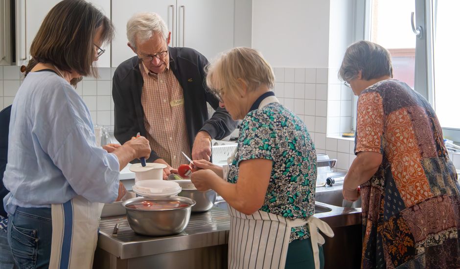 Ein Mann und drei Frauen arbeiten am Küchentisch