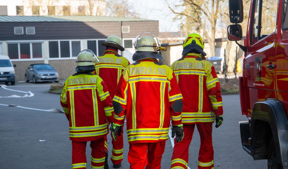 Vier Feuerwehrmänner von hinten