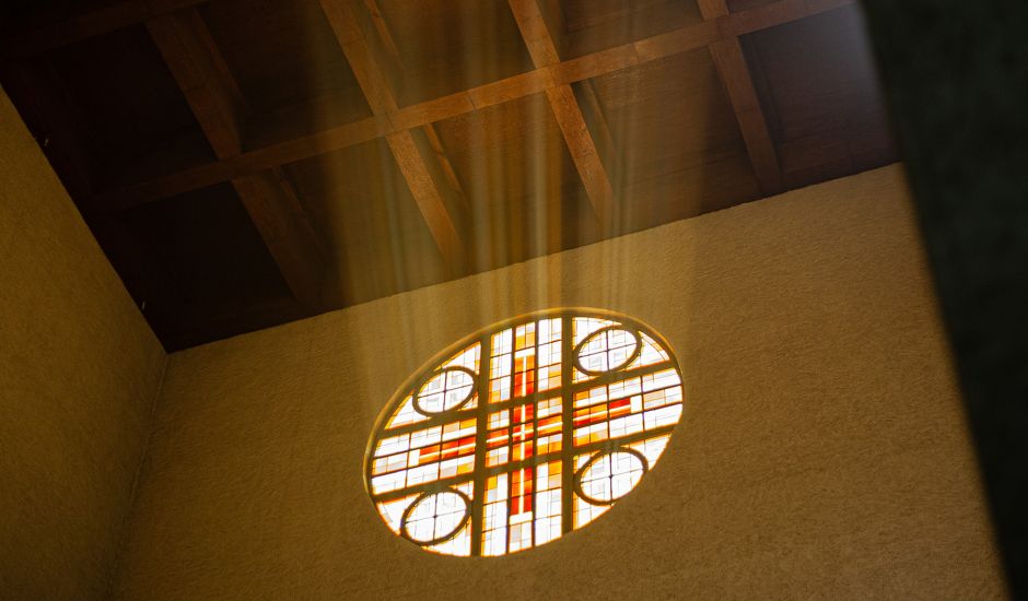 Lichtstrahlen, die durch ein Rundfenster in die Kirche fallen