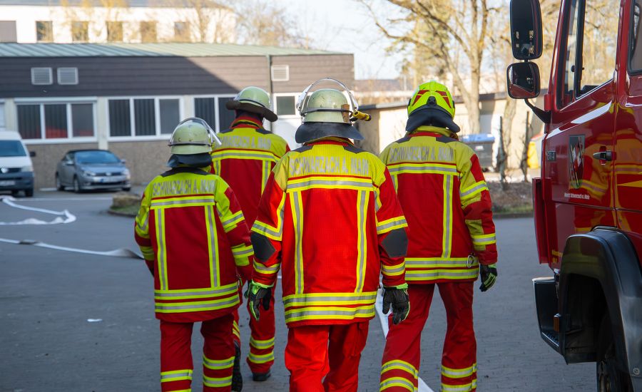 Vier Feuerwehrmänner von hinten
