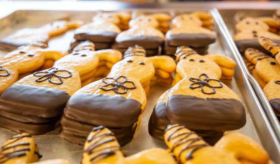 Blech mit Mürbteig-Osterhasen, die mit Schokolade verziert sind