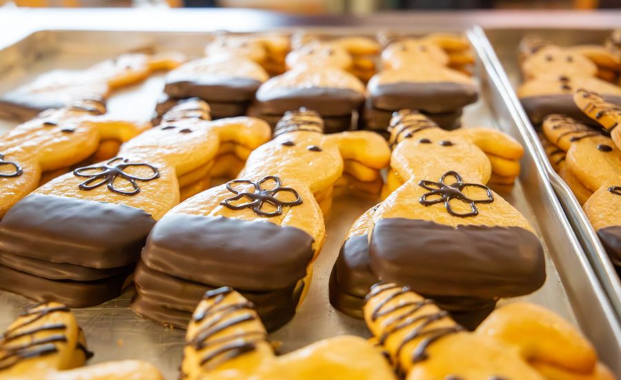 Blech mit Mürbteig-Osterhasen, die mit Schokolade verziert sind