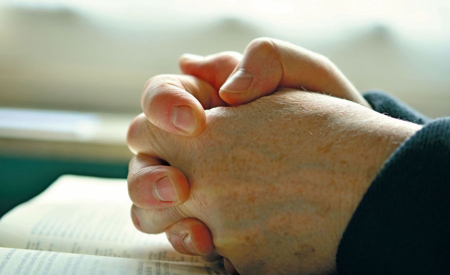 Betende Hände auf einer Bibel