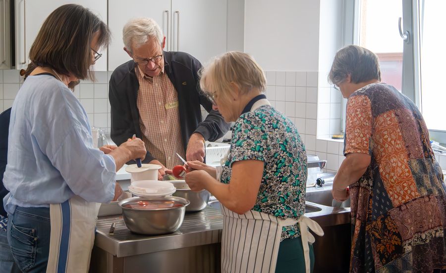 Ein Mann und drei Frauen arbeiten am Küchentisch