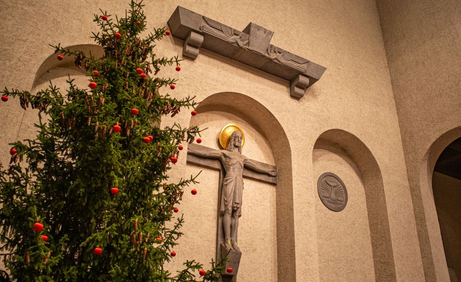 Weihnachtsbaum neben Kreuz