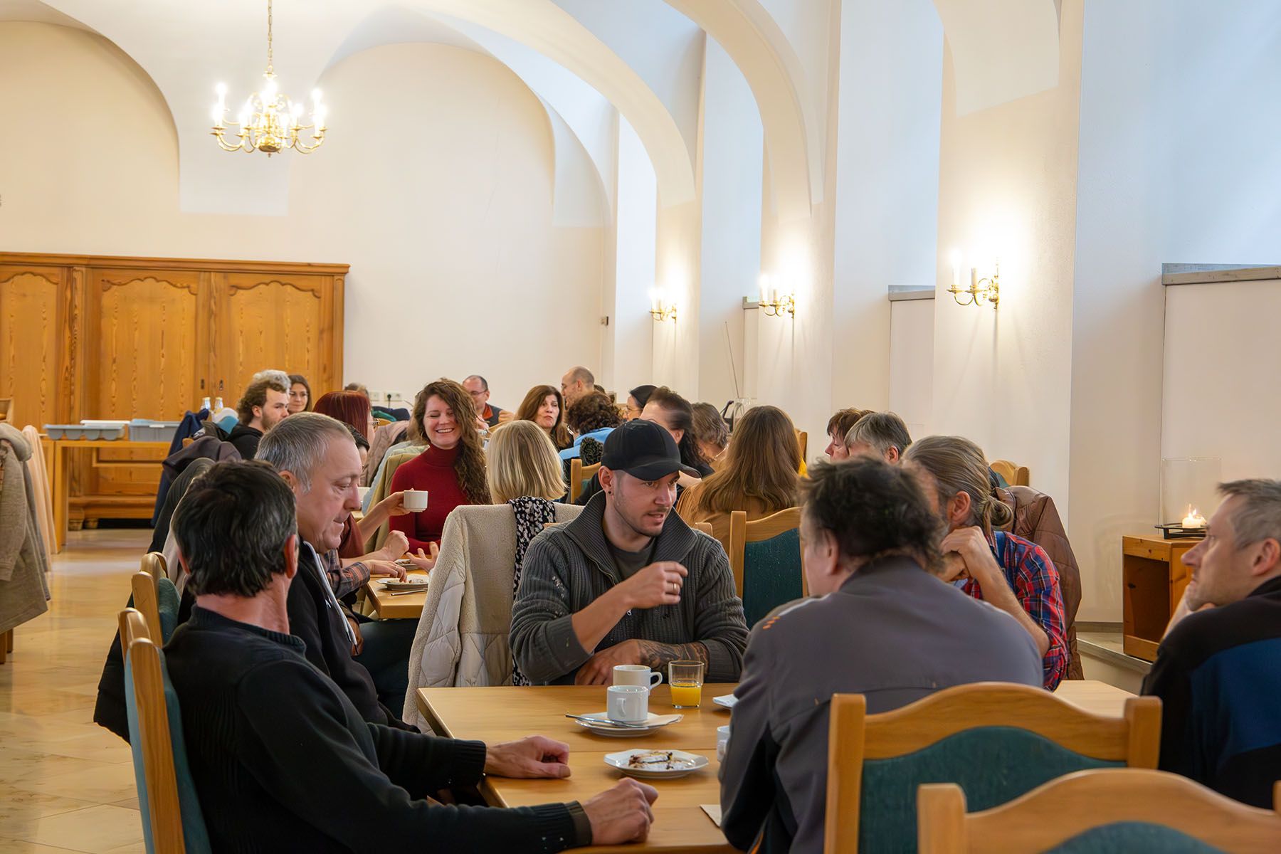 Blick auf mehrere Tische, die vollbesetzt sind