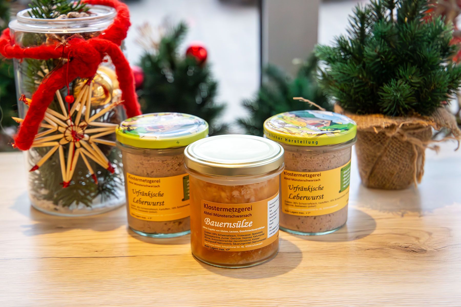 Drei Gläser mit Wurstspezialitäten in weihnachtlicher Deko