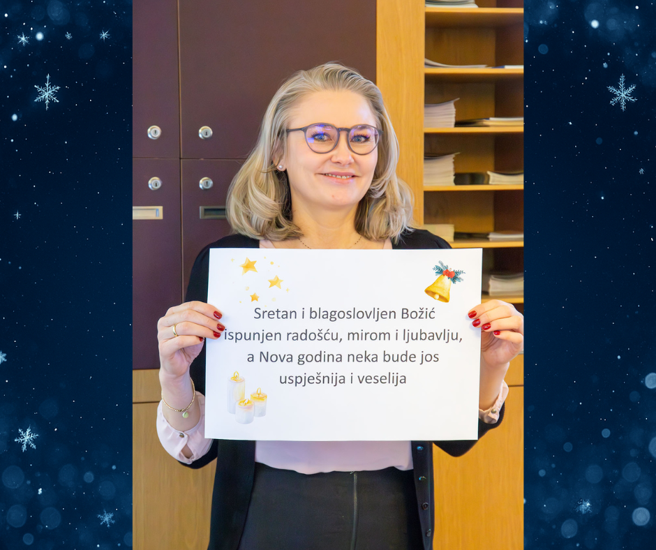 Mitarbeiterin hält Schild mit Weihnachtsgrüßen hoch