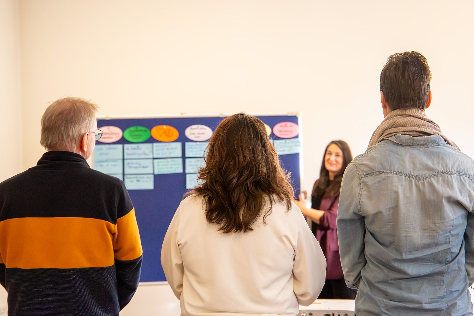 Drei Menschen vor Flipchart
