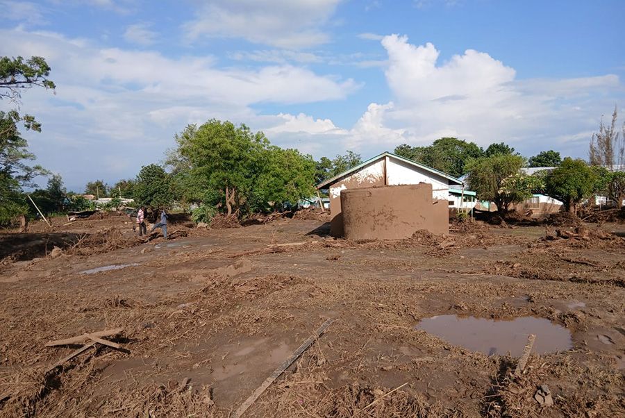 Erdhaufen vor Wohnhäuser, Pfütze als Erinnerung an die Überschwemmung